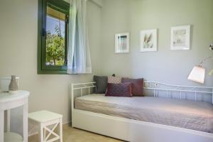 a small bed in a room with a window at Earth Apartment in Katelios