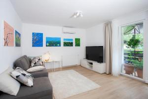 - un salon avec un canapé et une télévision dans l'établissement Apartment Galerija Bled, à Bled
