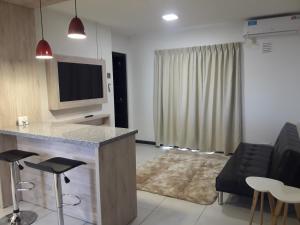 a living room with a bar and a tv and a couch at Departamento Torre Sofitel in Río Cuarto +12 photos