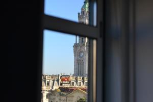 een raam met uitzicht op een klokkentoren bij Downtown Porto Spot - 2 bedroom Apartment in Porto