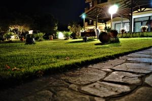 a cobblestone street in front of a house at night at Pension Karvounoskala in Stratoni
