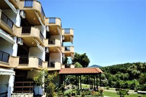 a building with a gazebo in front of it at Pension Karvounoskala in Stratoni