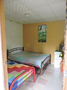 1 dormitorio con 1 cama y una pintura en la pared en Hostal Familiar El Ángel Panamá B&B, en Pajonal Arriba