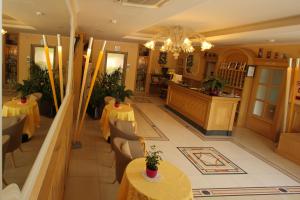 a restaurant with yellow tables and chairs and a chandelier at Hotel Fioroni in Bellagio