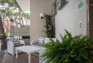 un patio con 2 sillas y una mesa en Hotel Villa Eugenia - 3 Stelle Superior con Private SPA e Piscina, en Lido di Jesolo