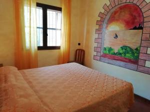 1 dormitorio con 1 cama y una pintura en la pared en Stanais, en Tortolì