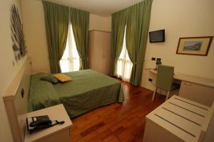 a hotel room with a green bed and a desk at Hotel Fioroni in Bellagio
