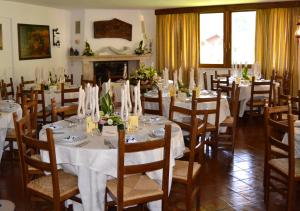 a dining room with tables and chairs and a fireplace at Bucaneve in Pescasseroli