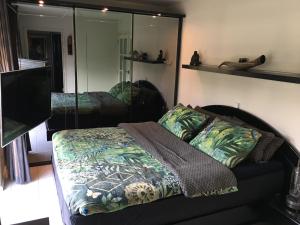 Schlafzimmer mit einem Bett und einem Spiegel in der Unterkunft Beach bungalow Hellevoetsluis in Hellevoetsluis