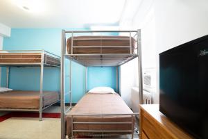 a room with three bunk beds and a flat screen tv at West Side YMCA in New York