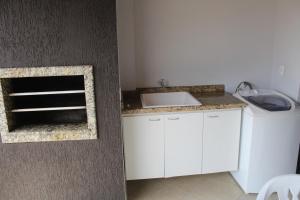 una cocina con fregadero y encimera en Apartamentos Morada do Sol, en Piratuba 11 fotos más