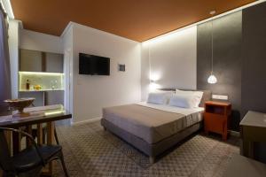 A bed or beds in a room at ATHENIAN YARD SUITES