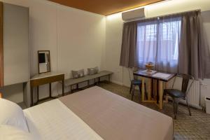 A bed or beds in a room at ATHENIAN YARD SUITES