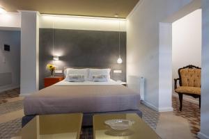 A bed or beds in a room at ATHENIAN YARD SUITES