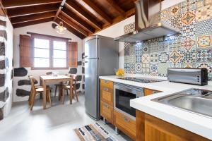 a kitchen with a stainless steel refrigerator and a table at Home2Book Nature Carrizales and Masca House & Wifi in Buenavista del Norte
