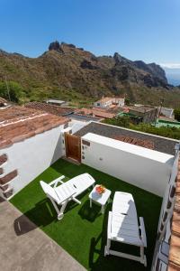 een patio met een tafel en stoelen op een dak bij Home2Book Nature Carrizales and Masca House & Wifi in Buenavista del Norte