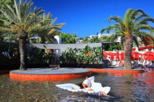 a woman is laying on an object in the water at a resort at Very Chic Bodrum Adult Only in Gümbet +55 photos