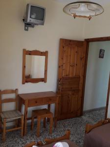 a room with a mirror and a table and a tv at EMILIOS SEE VIEW in Barbati