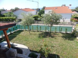 a garden with trees and a swimming pool at Apartman Duje in Petrcane