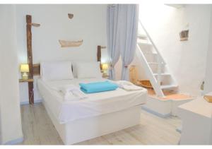 a bedroom with a white bed and a ladder at Vasealis & Seafis Sirma Klima in Klima