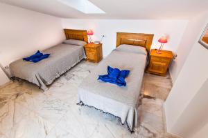 a bedroom with two beds with blue pillows at Apartamento Ocean Vista in El Cotillo