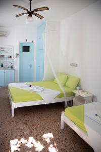 Un dormitorio con una cama verde y blanca y un techo en Paroscarmel studio-apartment, en Logaras
