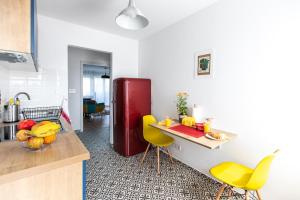 a kitchen with yellow chairs and a red refrigerator at Blue Sky Apartment in Zagreb