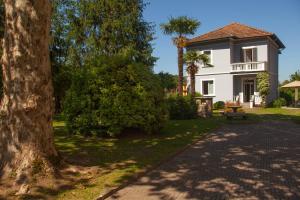 una casa blanca con un árbol al lado de una entrada en Villa Moiacchina Luxury Home, en Bevera