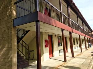 a building with a red door on a street at Red Carpet Inn Norwalk in Norwalk