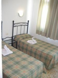 two beds with swans on them in a room at Bungalows Boston in Puerto Rico de Gran Canaria