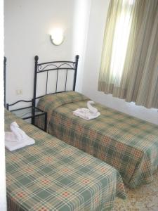 Dos camas con cisnes en una habitación en Bungalows Boston, en Puerto Rico de Gran Canaria