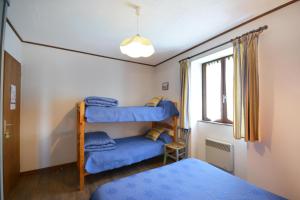 Grillon的住宿－Chambre d'Hôtes Au Vieux Chêne，一间卧室配有带蓝色毯子的双层床