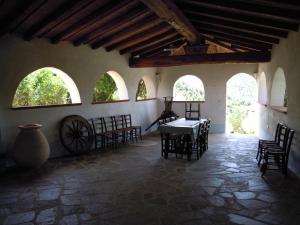 a room with a table and chairs and windows at Agriturismo Camisadu in Oliena