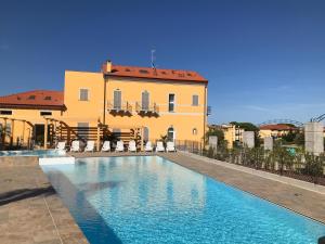 a large swimming pool in front of a building at Villa Canepa in Diano Marina