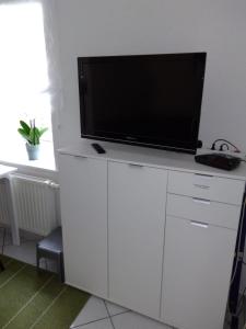 einen Flachbild-TV auf einem weißen Schrank in der Unterkunft Ferienwohnung Altstadt in Rottenburg