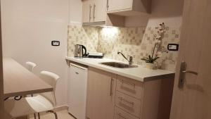 una pequeña cocina con fregadero y encimera en Vito's Parga View Apartments, en Parga