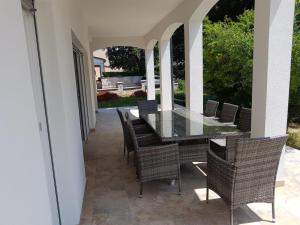 una mesa de cristal y sillas en un patio en Villa Iva, en Medulin