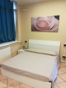 ロヴァートにあるMontorfano Roadのベッドルーム1室(ピンクのバラが壁に掛けられたベッド1台付)