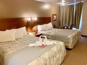 a hotel room with two beds with towels on them at Motel Invitation in Sainte-Marie