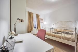 um quarto com uma cama, uma mesa e uma cadeira em Casa Laurentius em Pisa