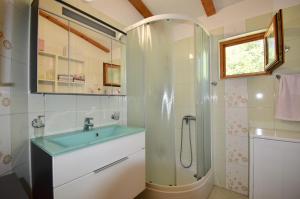 een badkamer met een wastafel en een douche bij Relaxing holiday house with terrace sea view in Medulin