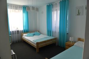 sypialnia z 2 łóżkami i niebieskimi zasłonami w obiekcie Na Kwiatkowskiego w mieście Sandomierz