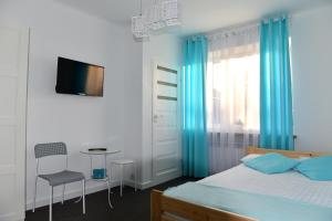 sypialnia z łóżkiem z niebieskimi zasłonami i stołem w obiekcie Na Kwiatkowskiego w mieście Sandomierz