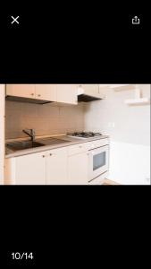 a white kitchen with a sink and a stove at Conchiglia 25 in Cupra Marittima