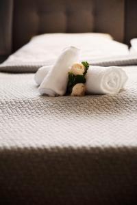 a couple of towels and flowers on a bed at 75m2 Apartament Kopernik z widokiem na Jasną Górę in Częstochowa +26 photos