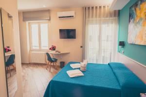 una camera da letto con un letto blu e asciugamani di Oltre il Mare Guest House a Gaeta