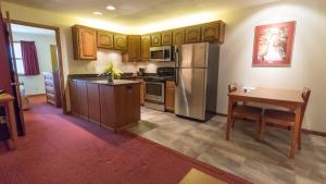uma cozinha com uma mesa e um frigorífico de aço inoxidável em Shepherd Mountain Inn & Suites em Pilot Knob