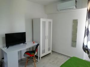 pokój z biurkiem, telewizorem i krzesłem w obiekcie Casa Mia w Weronie