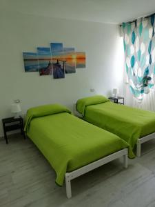 dwa łóżka w pokoju z zieloną pościelą w obiekcie Casa Mia w Weronie