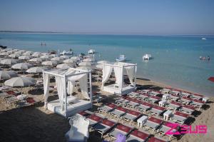 a bunch of umbrellas and chairs on a beach at Gioia del Mare in Il Monte